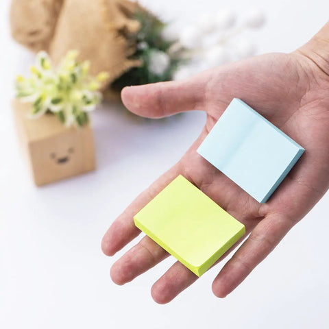 Hand holding Mini Sticky Notes One Point Five By Two Inches Bright Colors Self Stick Pads 24 Pads Per Pack 75 Sheets Per Pad