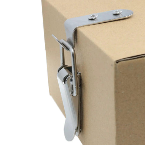 Close-up of stainless steel 90 degree toggle latch installed on cardboard box, heavy duty rust resistant cabinet hardware