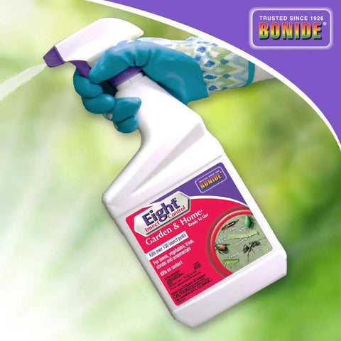 Gloved hand holding Eight Insect Control Garden And Home Outdoor Insecticide Kills Beetles Ants Aphids And More 32 Oz bottle