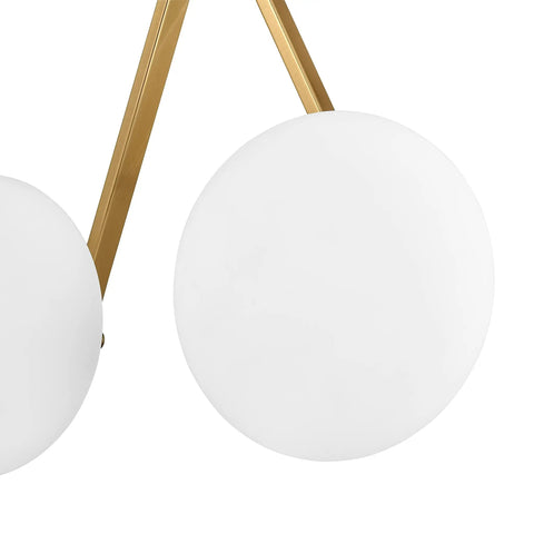 Close-up of Alby 2-Light Wall Sconce In Brushed Brass And White With Opal Glass Shades, focusing on opal shade and brass frame.