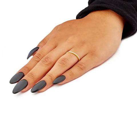 Real Deal 0.15 Ctw Genuine Round Cut Diamond Wedding Band Encased In Solid 14K Yellow Gold Machine Set on a hand with black nails.