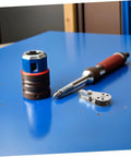 Workbench with tools including a ratchet screwdriver and socket on a blue surface, no Heavy Duty Stainless Steel Sailing Pulley Blocks visible.
