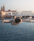 Ultra Lightweight 4K Drone With Camera For Beginners, 249g, 34 Minute Flight Time, flying over coastal cityscape