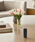 Pack Of 10 Black Kraft Paper Mailing Tubes 20ml Capacity With Snug Caps on a table near tulips