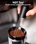WDT tool used for even coffee grounds, featuring multiple needles and a black ergonomic handle in an espresso setup.