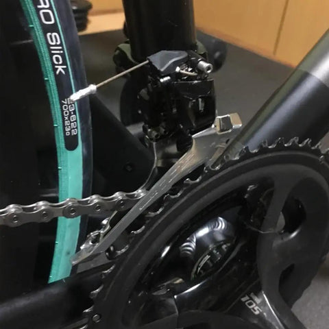 Close-up of budget friendly road bike front derailleur clip ring type for 31.8 to 34.9 mm tube size, aluminum alloy Shimano R2000 compatible.