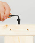Person using hex key with All In One 1680 Pcs Metric Hex Bolts And Nuts Set M2 To M5 With Washers And Black Finish on wooden board