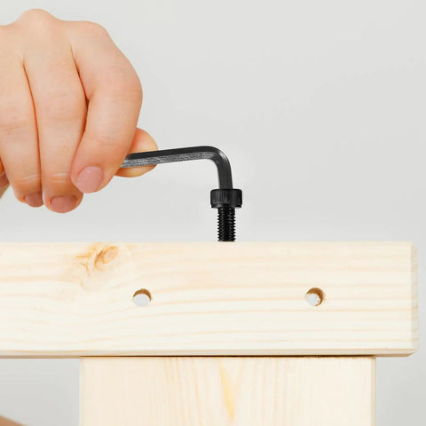 Person using hex key with All In One 1680 Pcs Metric Hex Bolts And Nuts Set M2 To M5 With Washers And Black Finish on wooden board