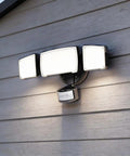 Patriot Lighting Tri-Head 180° Motion Sensing LED Black Security Flood Light Porch Light mounted on wall with motion sensor.