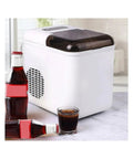 Fast Countertop Ice Maker Portable With Self Cleaning Setup Produces Crisp Cubes In Minutes next to drinks on a countertop.