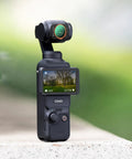 Close-up of DJI Osmo Pocket 4/3 camera with Osmo Pocket 4x3 Magnetic CPL Filter, capturing vibrant outdoor scene.