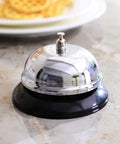 Desk Bell For Service And Reception With Ring Sign, Clear Call Bell For Front Desk, Office, Hotel, Hospital, School, Dinner Bell, Easy To Use, Loud Ring, Double-Sided Sign For Assistance. Chrome stainless steel desk bell with black base on countertop.