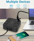 2 Prong To 3 Prong Outlet Adapter With 4 USB Ports And 6 AC Outlets Desktop Charging Hub on desk next to laptop and charging phone.