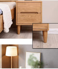 Four Pack Solid Oak Wood Table Legs, Four Inch Tapered Replacement Furniture Feet showcased under a nightstand in a bedroom.
