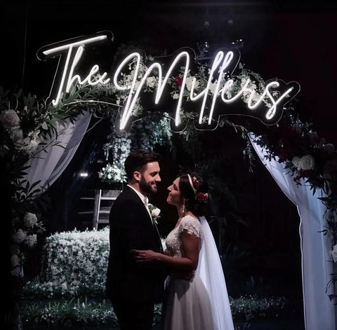 Custom Neon Sign LED Light Up Name Sign Personalized For Weddings Bars Salons And Businesses Lit Name Decor For Events Birthdays And Parties Unique Gift displayed above bride and groom at wedding.