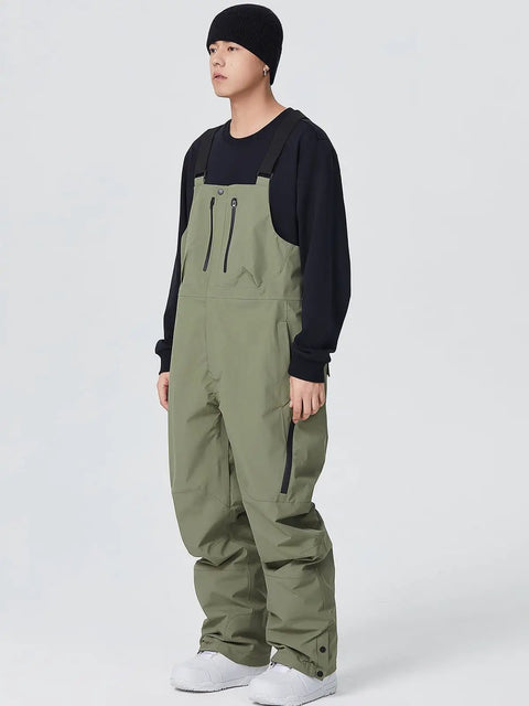Model wearing army green Waterproof Ski Bibs Men Winter Snow Pants Overalls Snowboarding Outdoor Sports Breathable High Stretch.