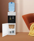 Standing Hot And Cold Water Cooler Dispenser With Top Loading On Demand 5 Gallon Bottle Compatible in a living room setting