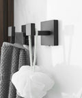 Four Piece Black Stainless Steel Bathroom Accessory Set With 23.6 Inch Towel Bar 8.2 Inch Towel Bar Toilet Paper Holder And Hooks Wall Mounted For A Sleek Dope Home Upgrade featuring black wall-mounted hooks holding towel and sponge