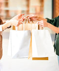 People exchanging White Gift Bags With Handles 100 Pack 8.25x4.3x10.6 Inch Bulk Kraft Paper Bags for Shopping Retail Weddings Parties