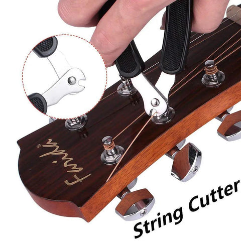 Close-up of a hand using a heavy duty string cutter on guitar tuning pegs. Upgrade Your Guitar Game With This Pro 3-In-1 String Winder Tool.