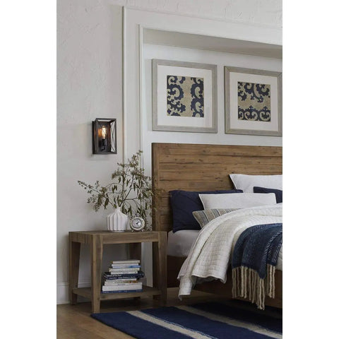 Briarwood Antique Bronze One Light Wall Sconce With Faux Wood Look in a bedroom, mounted on wall, next to bed