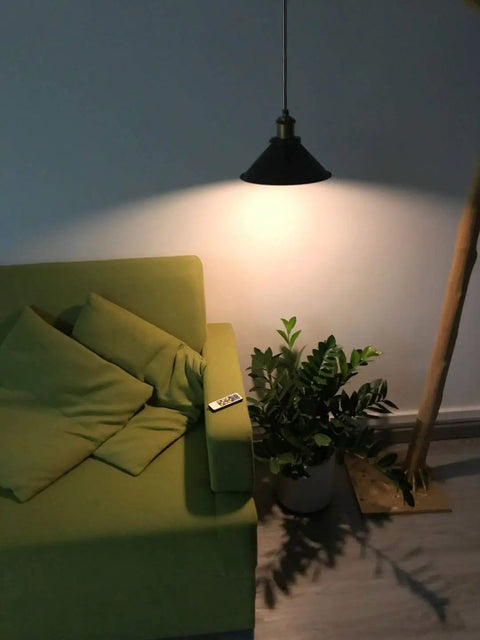 3-Light Battery-Powered LED Pendant Kit With Remote Control illuminating a sofa and plant, black retro finish