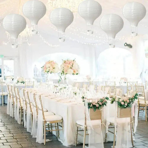 Ten Pack 12 Inch White Hanging Hot Air Balloon Paper Lanterns For Weddings Valentines Birthday Parties Baby Showers Engagement Archways And Home DIY Decor displayed over elegant wedding tables.