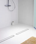 Bathroom with 36 Inch Matte Black Linear Shower Drain With Reversible 2 In 1 Tile Insert Cover Built To Last 304 Stainless Steel Rectangle Floor Drain For Modern Bathrooms CUPC Certified Includes Accessories visible on white tiled floor.