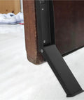 Close-up of space saving stainless steel door stopper with multi-function design and rubber base for indoor and outdoor doors no drilling punch free install heavy duty security for top or bottom of doors in use on a wooden door.