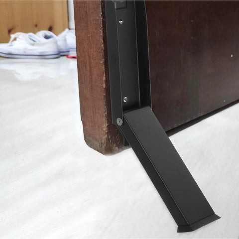 Close-up of space saving stainless steel door stopper with multi-function design and rubber base for indoor and outdoor doors no drilling punch free install heavy duty security for top or bottom of doors in use on a wooden door.