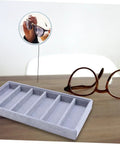 Solid Six Grid Sunglasses Storage Plate And Jewelry Display Box For Women showing grey six compartment organizer on desk with sunglasses.