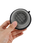 Hand holding a grey anti-skid washer foot mat from the 4 piece set with height-adjustable vibration pads for washing machines.