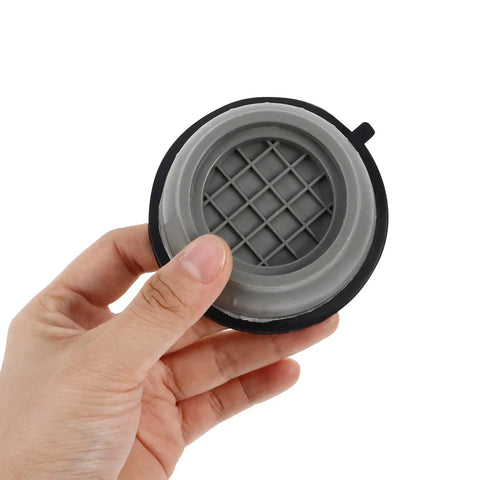 Hand holding a grey anti-skid washer foot mat from the 4 piece set with height-adjustable vibration pads for washing machines.