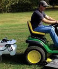 Man using Deluxe 25 Gallon Trailer Sprayer with Polyethylene Tank 12V Demand Pump on lawn tractor for herbicide spraying