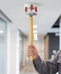 Person holding Top Shelf Aluminum Claw Wrench For Ceiling Smoke Detectors And Fire Alarms Universal Sensor Disassembly Kit above ceiling.