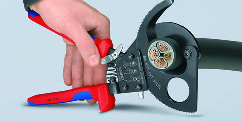 Hand using 95 31 280 SBA Copper And Aluminum Cable Cutters With One Hand Ratchet, showing clean cut on multiple copper wires.