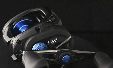 Close-up of Hagane Body Fishing Reel With Super Free Spool And Variable Braking, showing multi-color finish and control details.