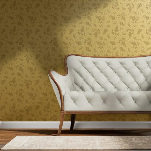 Straight Up Pink Vintage Floral Gold Metallic Wallpaper That Brings Major Style Points To Any Spot With Quick Paste Routine And Sustainable American Made Specs Type I Fire Safe Wallcovering Solid Finish on wall behind a cream sofa.
