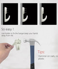 Installing the Dope No Damage Picture Hanging Kit With 68 Invisible Nails on concrete wall using hammer.
