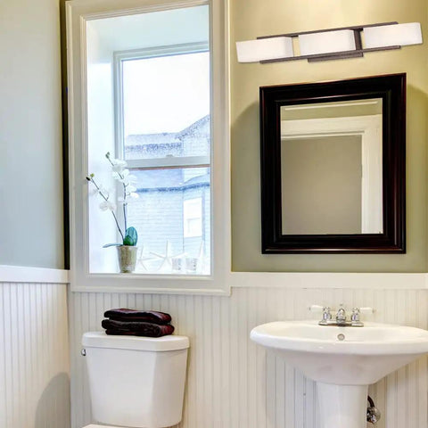 Facet 25.25 Inch 3 Light Bathroom Vanity Fixture In Tuscana Finish With White Opal Glass above a bathroom mirror and sink
