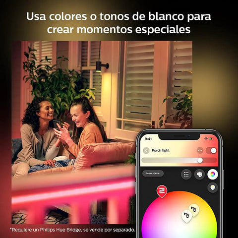 Two people enjoying evening on patio with Hue White And Color Ambiance Outdoor LightStrip 2m 7ft and smartphone color control app visible