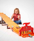 Child playing with Six Car Super 6 Lane Raceway With 8 Foot Roll Up Track, Realistic Lights And Sounds, Includes Six 1 64 Scale Vehicles.