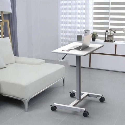 Hella Sturdy Height Adjustable Mobile Standing Desk With Smooth Glide Casters And Rustproof White Steel Top Portable Laptop Workstation and Rolling Podium for Home Office Space next to a sofa.