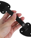 Hand holding Barn Door Handles Set Black 2 Pack Go To Rustic Gate Pull Hardware For Cast Iron Garage And Wood Doors Indoor And Outdoor Use