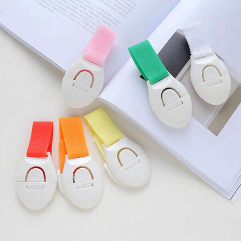 Stick On Cabinet Locks 10 Pack Self Adhesive PP Material Kid Proof Latches in assorted colors displayed on a book.