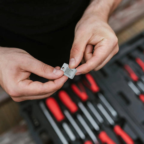 Person holding a silver clip from Badass Solar Panel Mount Clips And Spring Steel Brackets For Rooftop Setup Heavy Duty Corrosion Resistant Universal Pv Hardware.
