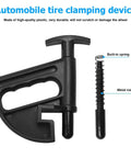 Front view of a black automobile tire clamping device with built-in spring and metal rod, made of durable plastic.