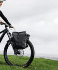 Cyclist using Spider Front Rack And Pannier Receiver For MTB And EMTB, Quick Release Front Cargo System, on green hill