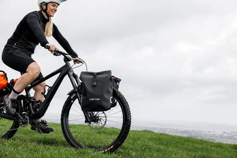 Cyclist using Spider Front Rack And Pannier Receiver For MTB And EMTB, Quick Release Front Cargo System, on green hill