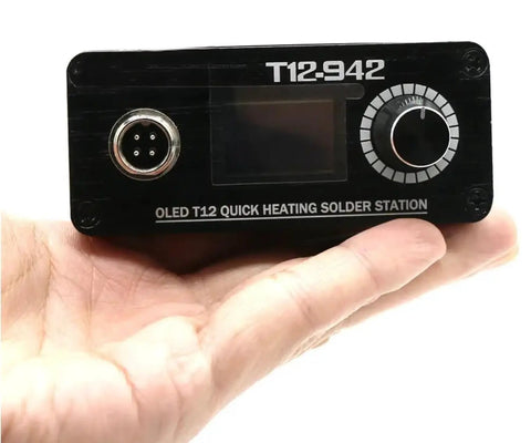 Person holding OLED T12 solder station, part of Beefed Up High Power Digital Soldering Station With 75W Quick Heat For RC Toys And FPV Builds Adjustable Temperature Auto Sleep Auto Power Off Includes T12 K Solder Tip Compatible With Common Power Adapters Power Supply Not Included.